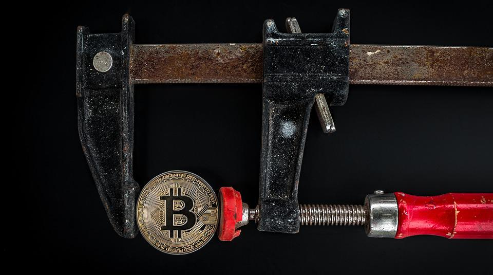 A working tool smashing a bitcoin coin